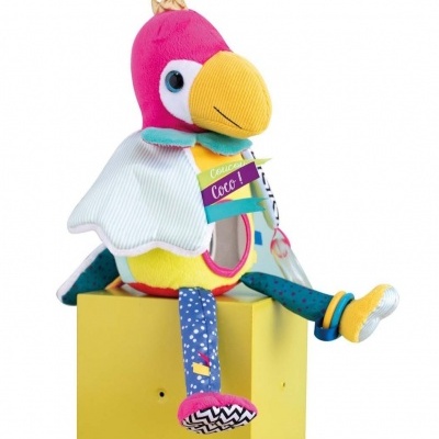 Pelúcia de papagaio colorida sentada numa caixa amarela