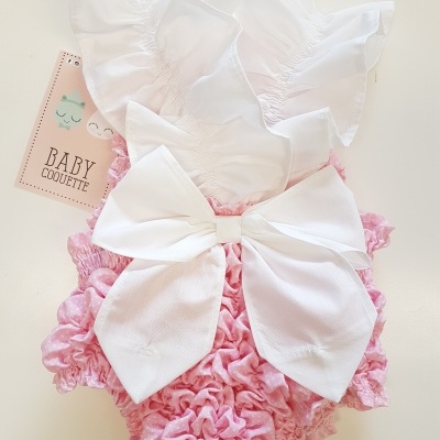 Macacão de bebé cor-de-rosa com laço branco e alças com folhos
