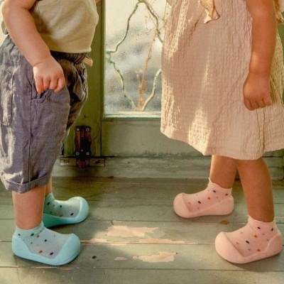 Crianças em pé com sapatos coloridos e meias estampadas