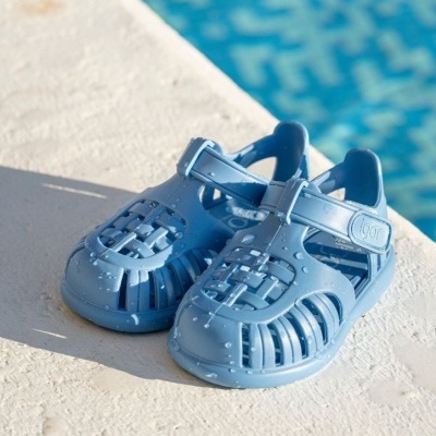 Sandálias de praia azuis em plástico junto a piscina