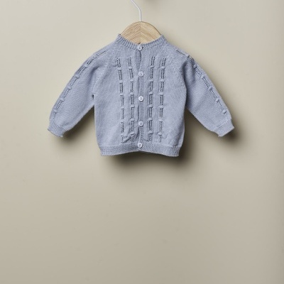 Casaquinho de bebé cinza claro em malha com botões, pendurado no cabide