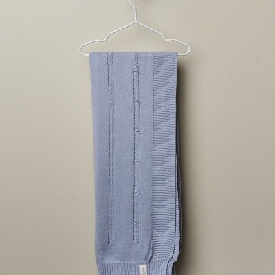 Cachecol azul malhado pendurado num cabide branco