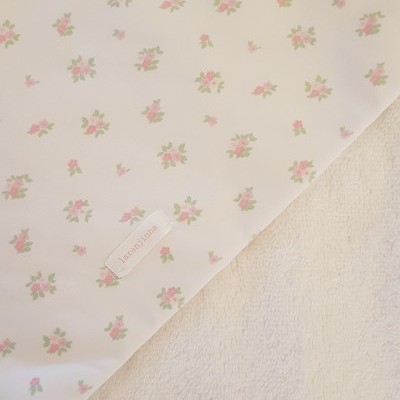 Tecido branco com padrão de flores pequenas e etiqueta FLOAUTISTA