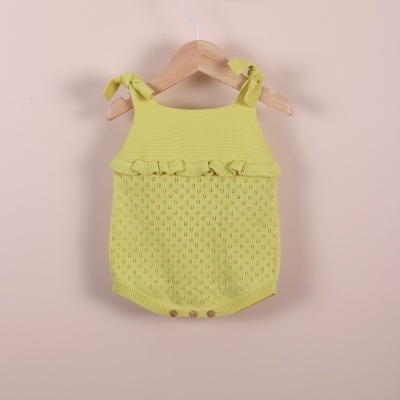 Macacão de bebé amarelo em malha com alças e babado pendurado num cabide
