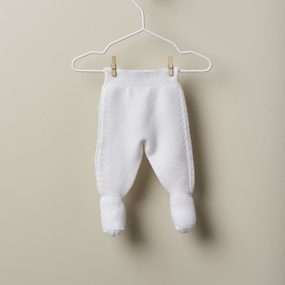 Calças de bebé brancas em malha tricotada penduradas num cabide branco
