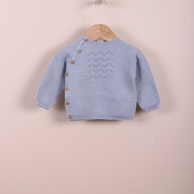 Camisola de bebé azul clara em malha com botões castanhos e padrão decorativo