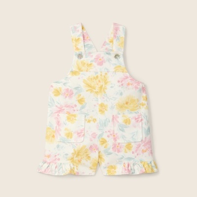 Jardineira curta infantil com padrão floral amarelo, rosa e azul sobre branco