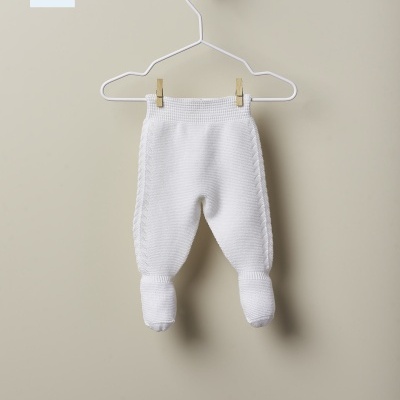 Calças de bebé brancas em malha penduradas num cabide branco