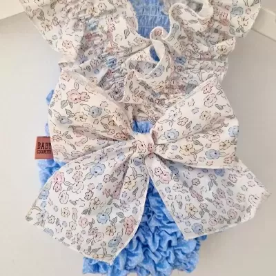 Roupa de bebé azul com laço florido