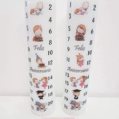 Duas velas brancas com números, crianças ilustradas e texto Feliz Aniversário