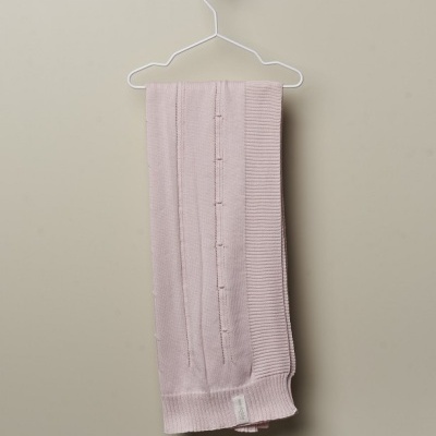 Cachecol cor de rosa claro em malha pendurado num cabide branco