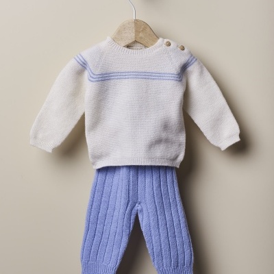 Conjunto de bebé em malha branca e azul pendurado num cabide de madeira