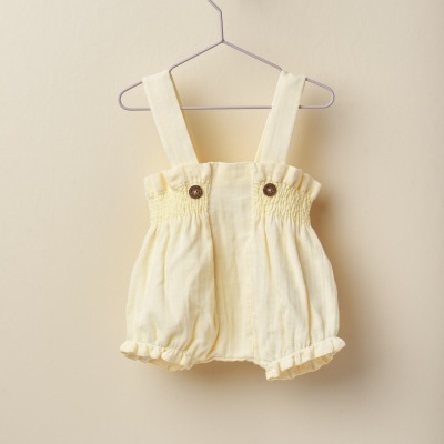 Macacão curto de bebé amarelo claro com alças e botões em madeira