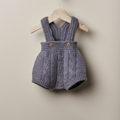 Jardineira cinzenta de malha para bebé num cabide de madeira