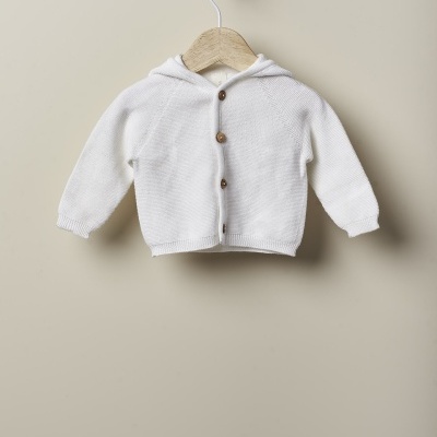 Casaco de malha branco com capuz e botões de madeira pendurado num cabide de madeira