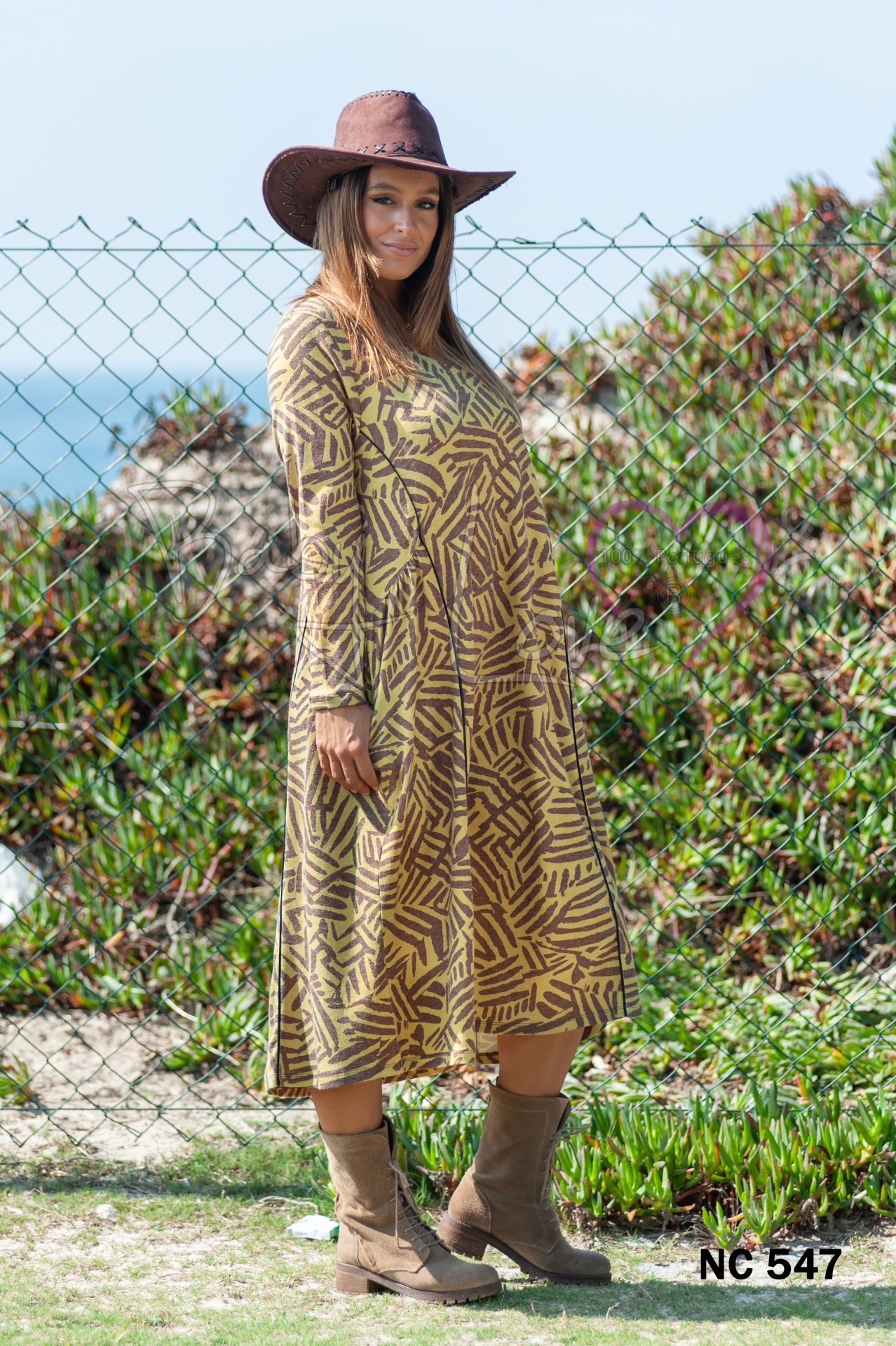 VESTIDO Vestido comprido com padrão geométrico castanho e bege, botas e chapéu castanhos ao ar livre