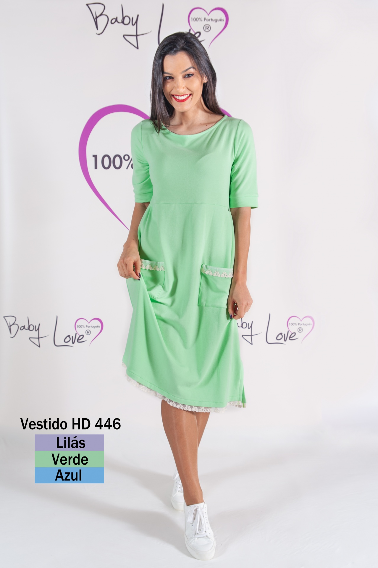 VESTIDO MIDI COMFY Mulher a usar vestido verde com bolsos e detalhe rendado em fundo branco com texto