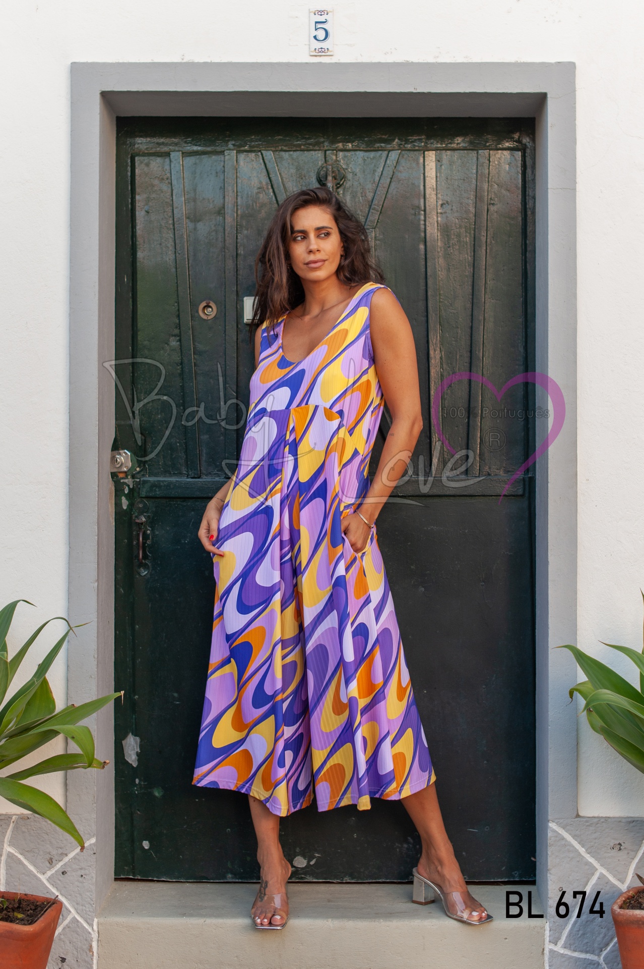 MACACÃO CULOTTE Macacão comprido colorido usado por mulher em porta verde