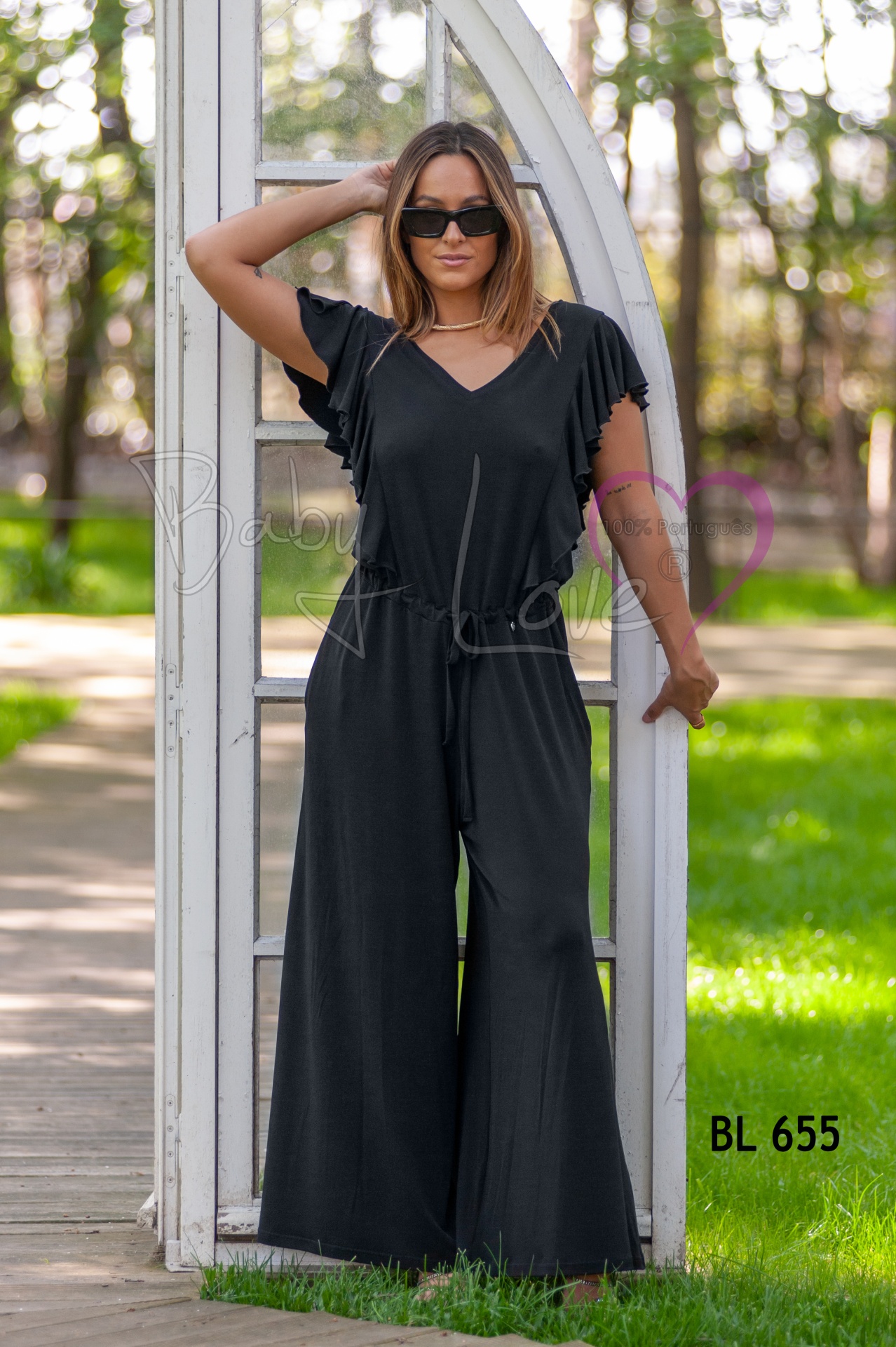 MACACÃO LISO C/ FOLHO Macacão preto com mangas franzidas e cinto, em ambiente exterior