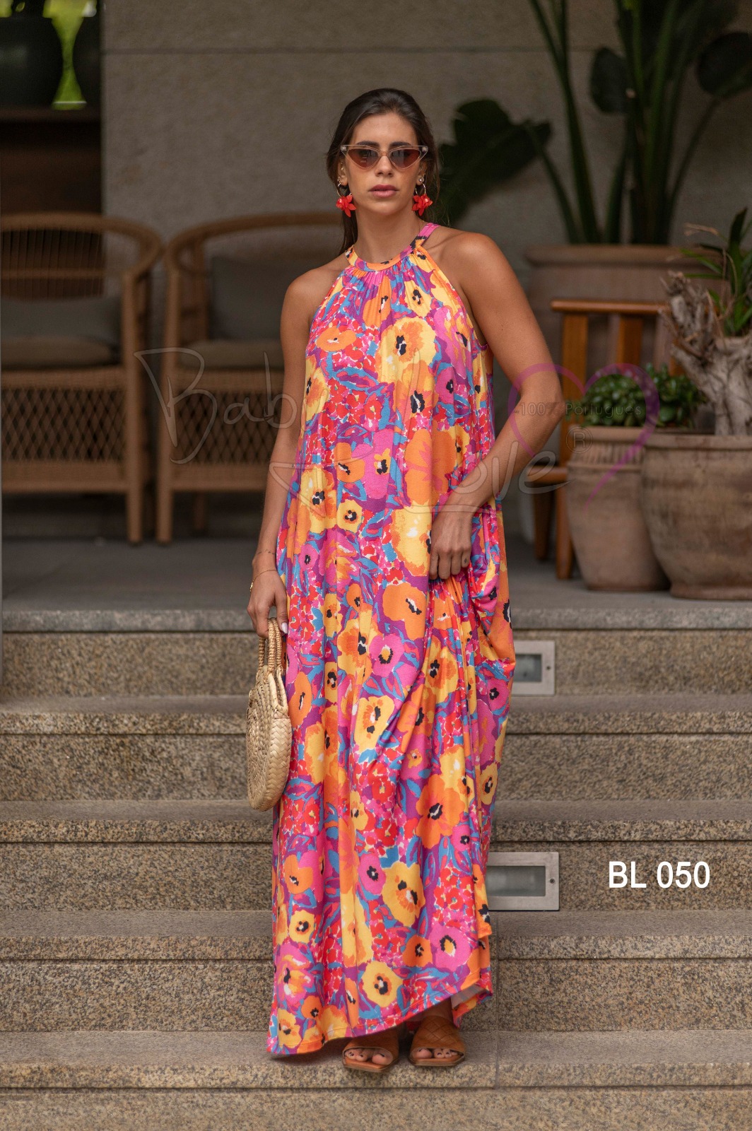 VESTIDO COMPRIDO PADRÃO FLORAL Mulher com vestido longo floral colorido e acessórios na escadaria