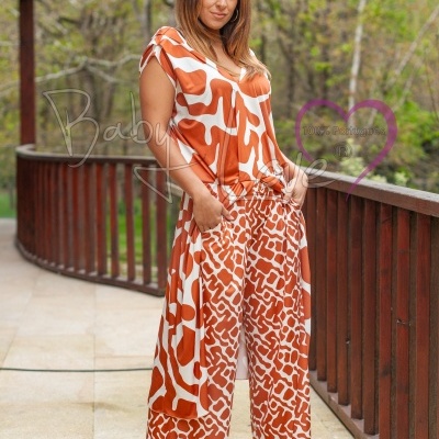 Mulher a usar macacão estampado em tons de laranja e branco numa varanda ao ar livre