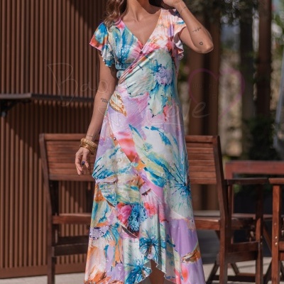 Mulher com vestido comprido floral colorido, mangas curtas e óculos escuros