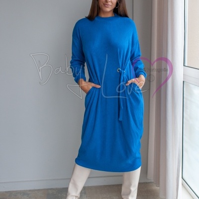 Vestido midi de malha azul com cinto e bolsos, usado com botas brancas em ambiente interior