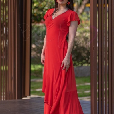Vestido vermelho de mulher com manga curta e decote em V, uso de acessórios e cenário exterior