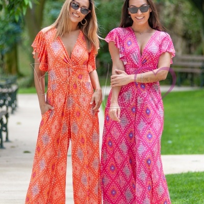 duas mulheres de macacões maxis coloridos com padrão geométrico ao ar livre