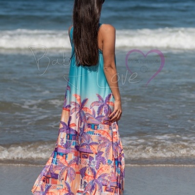 Vestido longo com padrão tropical em praia, vista de trás