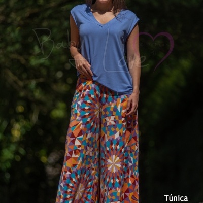 Mulher com túnica azul e calças geométricas coloridas ao ar livre