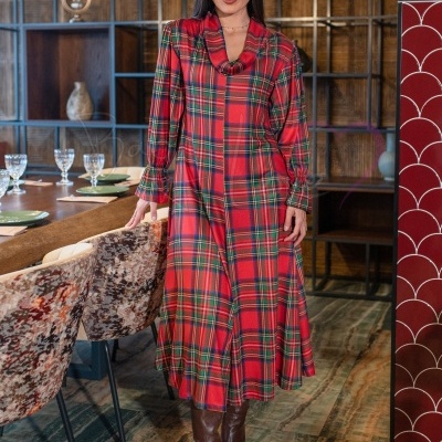 Vestido xadrez comprido vermelho e botas castanhas em ambiente interior