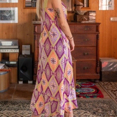 Vestido comprido colorido com padrão geométrico num ambiente interior