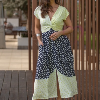Vestido midi amarelo claro e azul escuro com padrão de manchas, usado por mulher com óculos de sol e sandálias de salto pretas.