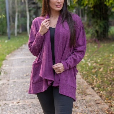 Mulher com cardigan roxo de tecido suave e bolsos, ao ar livre em caminho de pedra