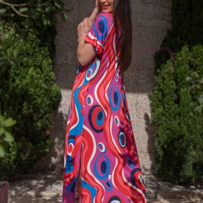 Vestido longo colorido com padrão psicadélico e sandálias vermelhas