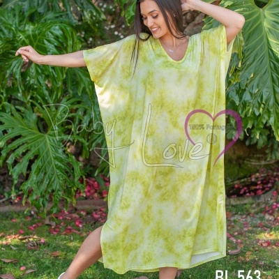 Vestido amarelo claro com padrão tie-dye verde, decote em V, manga curta larga, comprimento midi, mulher no jardim