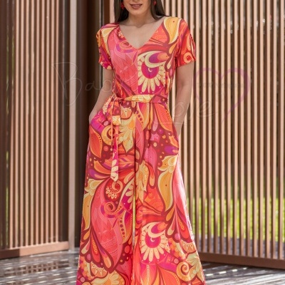 Vestido longo colorido com padrão abstrato em rosa, laranja, vermelho e amarelo.