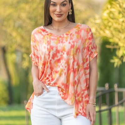 Blusa feminina estampada com calças brancas em ambiente exterior