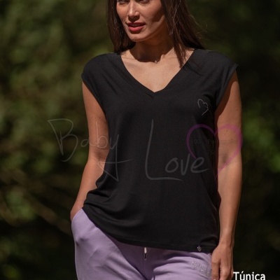 Mulher com túnica preta e calças lilás ao ar livre