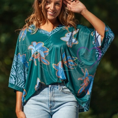 Blusa verde-petróleo com padrão floral e padrão animal print nas mangas vista ao ar livre