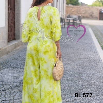 Macacão comprido amarelo com padrão tie-dye verde e mala de palha redonda