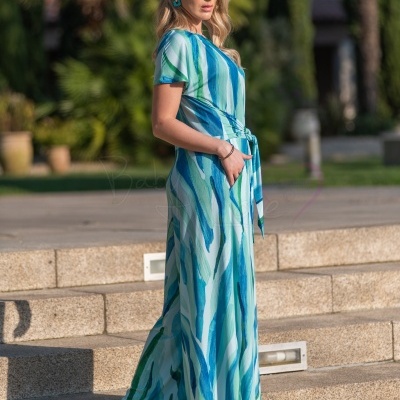 Vestido comprido azul e verde com padrão listrado, cinto e bolsos, usado com salto alto