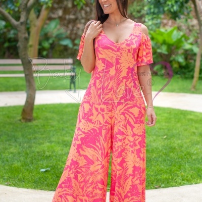 Macacão coral com padrão floral amarelo, usado por mulher em jardim