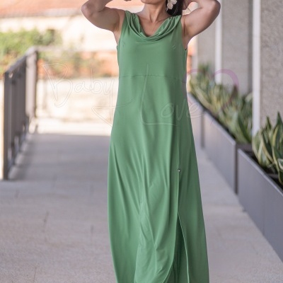 Vestido longo verde sem mangas com decote drapeado usado por mulher com sandálias cinza