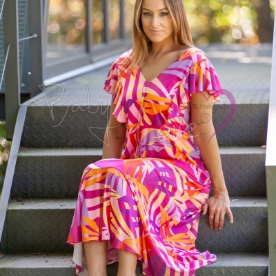 Vestido longo mulher padrão rosa, laranja e roxo, mangas curtas, decote em V, sentado em escadas metálicas