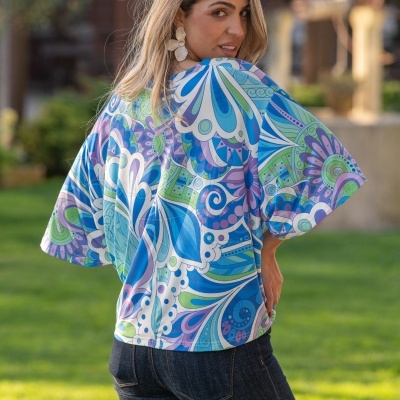 Blusa feminina azul e verde com padrão abstrato vista de costas