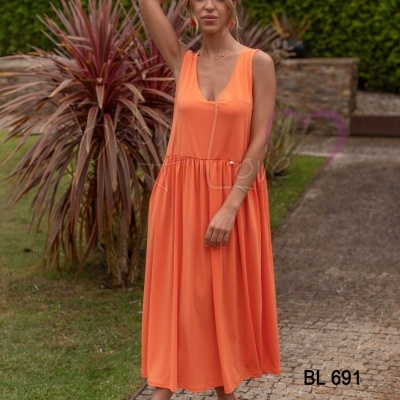 Vestido longo laranja sem mangas com decote em V usado no jardim