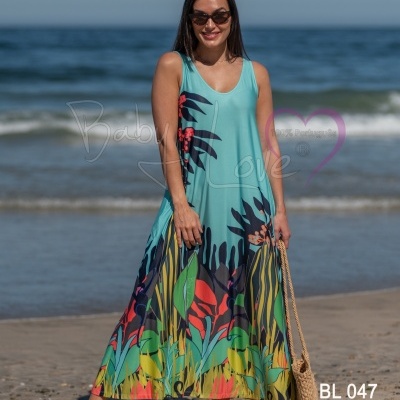 Vestido longo azul com padrão floral colorido na praia