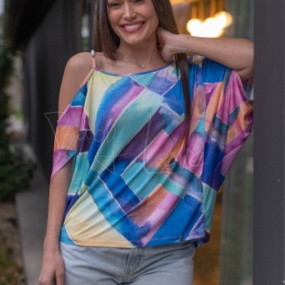 Mulher com t-shirt colorida abstrata e calções de ganga, fundo urbano